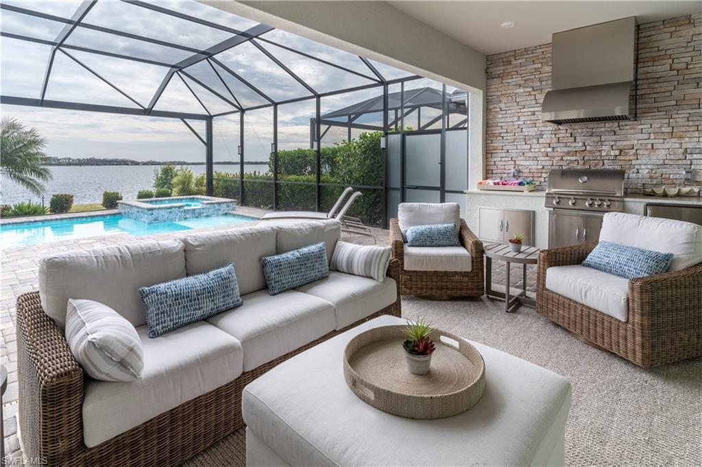 View of patio / terrace featuring a water view, area for grilling, grilling area, glass enclosure, and outdoor lounge area