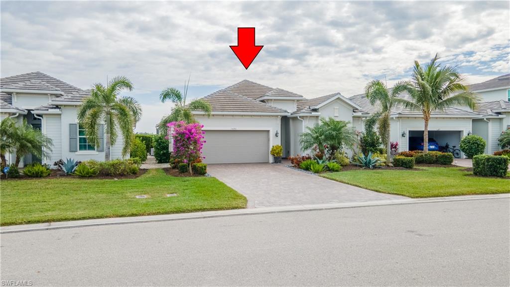 View of front facade featuring a garage and a front yard