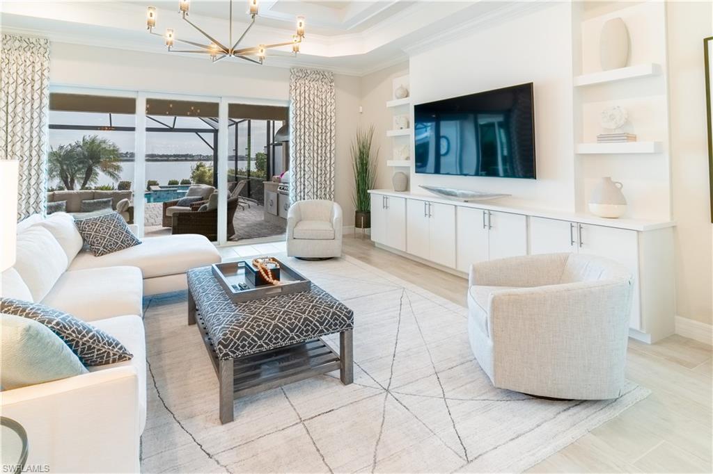 Living room with an inviting chandelier, crown molding, and built in features