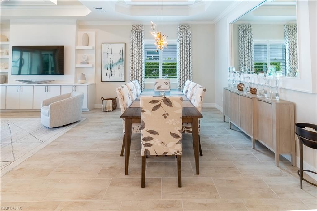 Dining space featuring an inviting chandelier, a tray ceiling, and ornamental molding