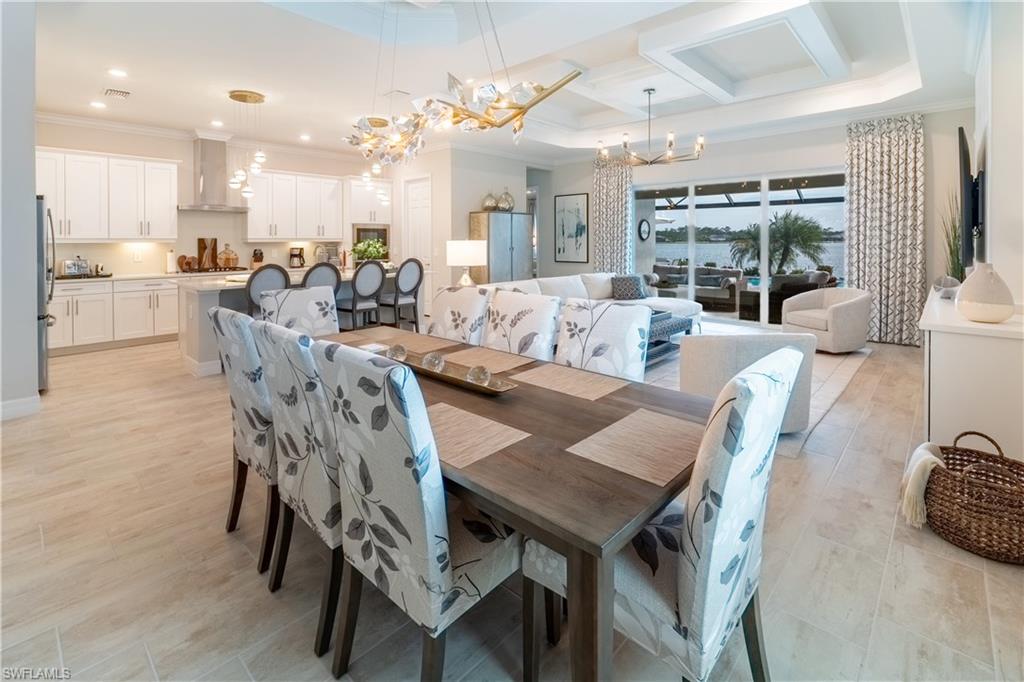 Dining room with crown molding, coffered ceiling, and an inviting chandelier