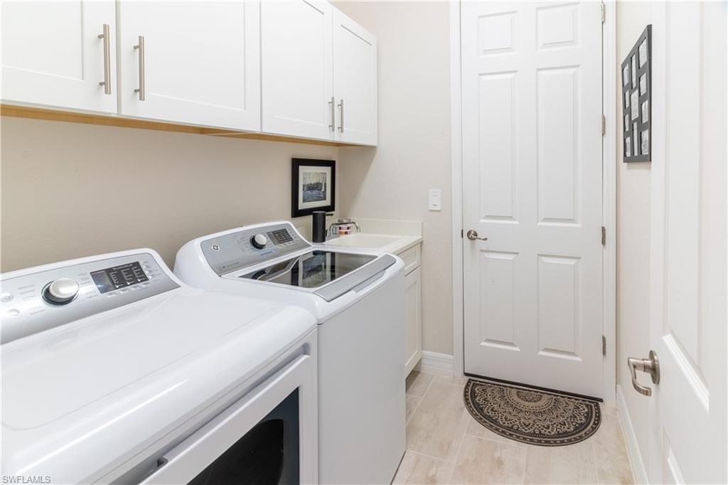 Laundry area featuring cabinets, sink, and washer and dryer
