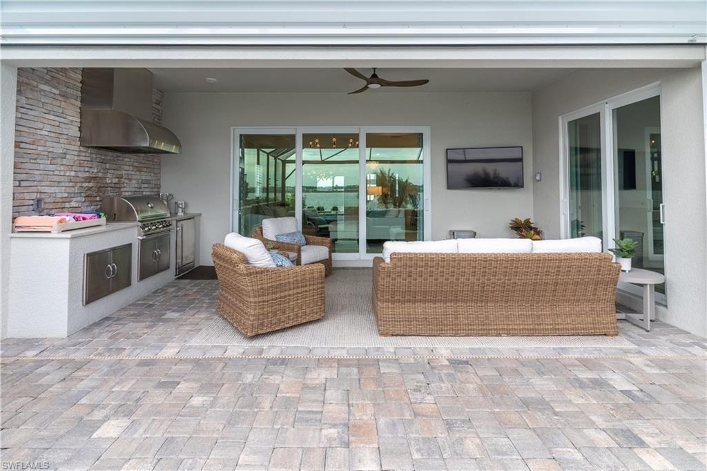View of patio featuring a grill, area for grilling, an outdoor hangout area, and ceiling fan