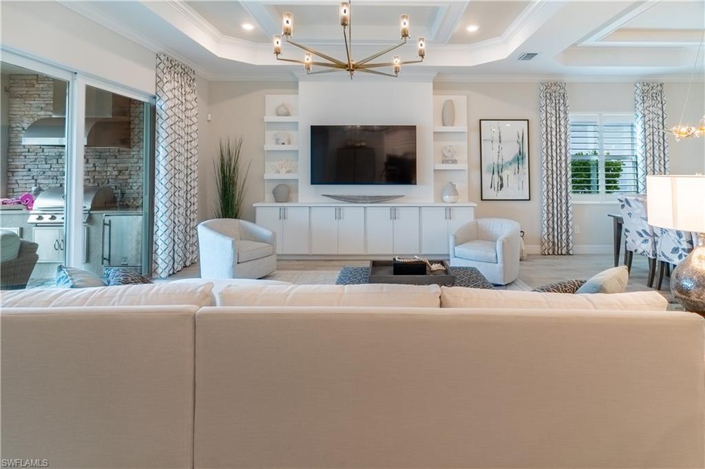 Living room with an inviting chandelier and ornamental molding