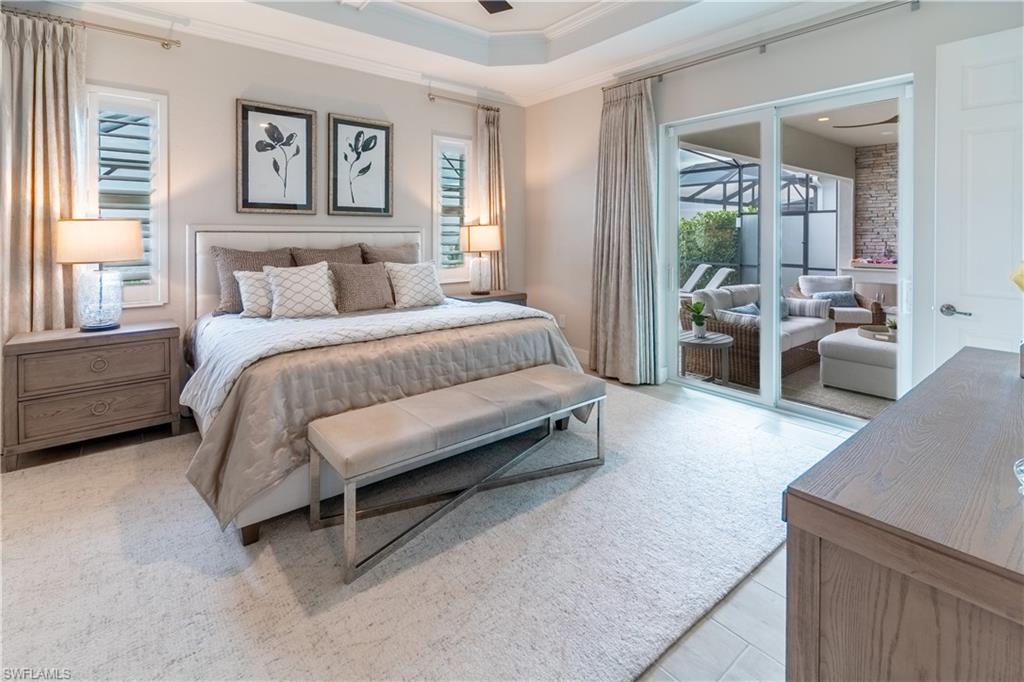 Bedroom featuring crown molding, access to exterior, and a raised ceiling
