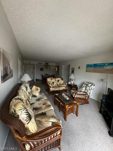 Living area featuring carpet flooring, ceiling fan, and a textured ceiling