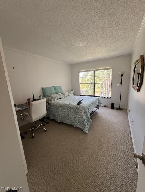 Carpeted bedroom featuring a textured ceiling and crown molding