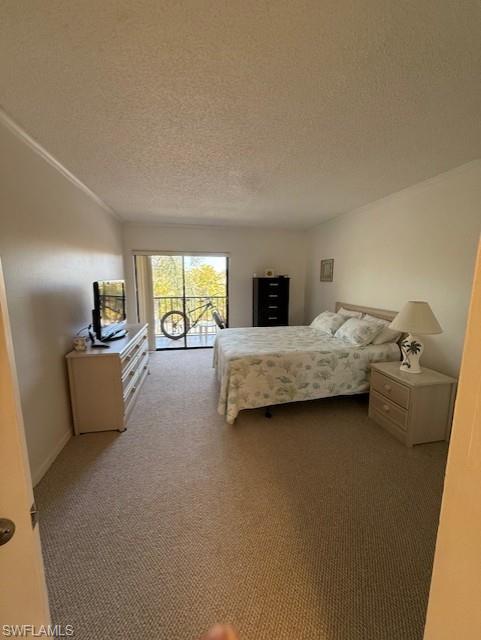 Bedroom featuring access to outside, dark colored carpet, and a textured ceiling