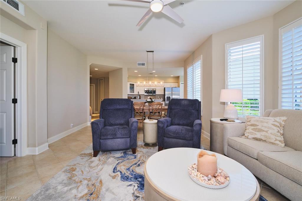 Living area featuring a ceiling fan and light tile patterned floors