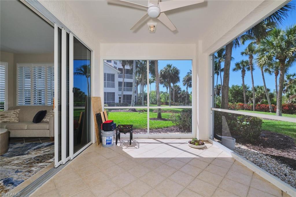 Unfurnished sunroom with a ceiling fan, tile patterned floors, and plenty of natural light