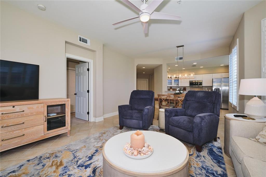 Living area with a ceiling fan and light tile patterned floors