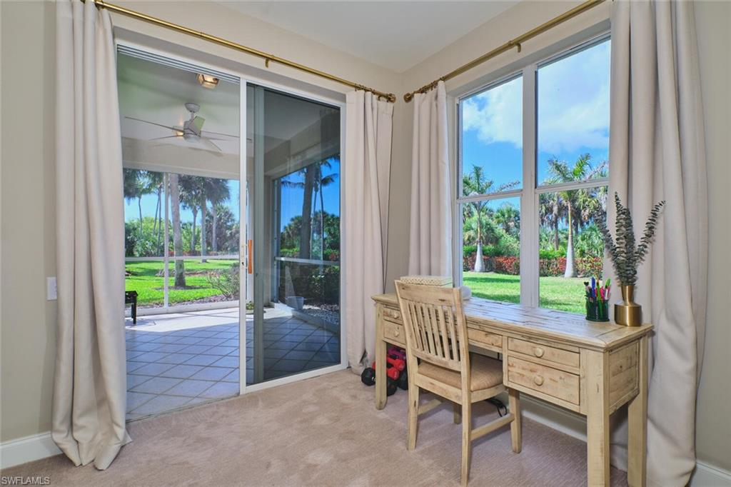 Office space with a ceiling fan, light colored carpet, and plenty of natural light