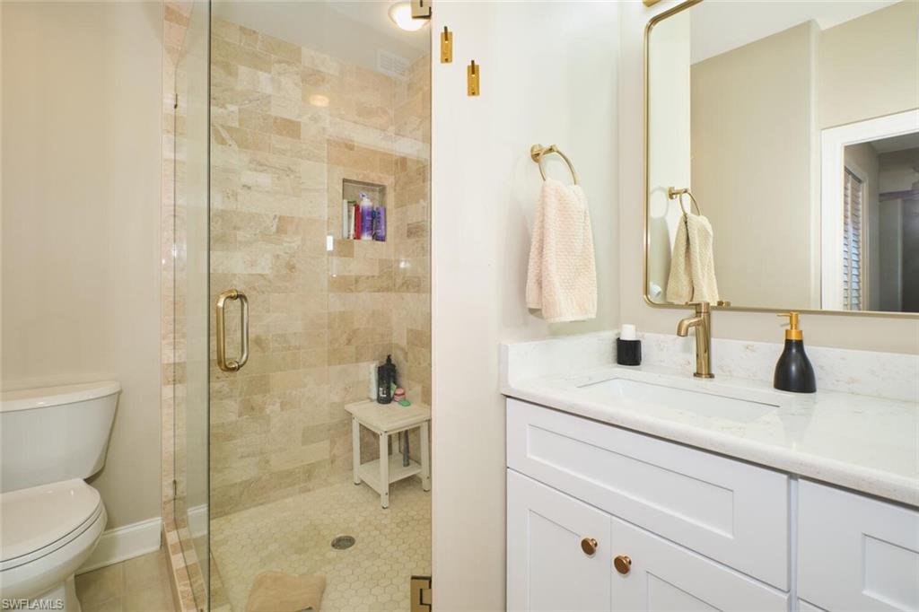 Bathroom with vanity, a shower stall, and tile patterned flooring