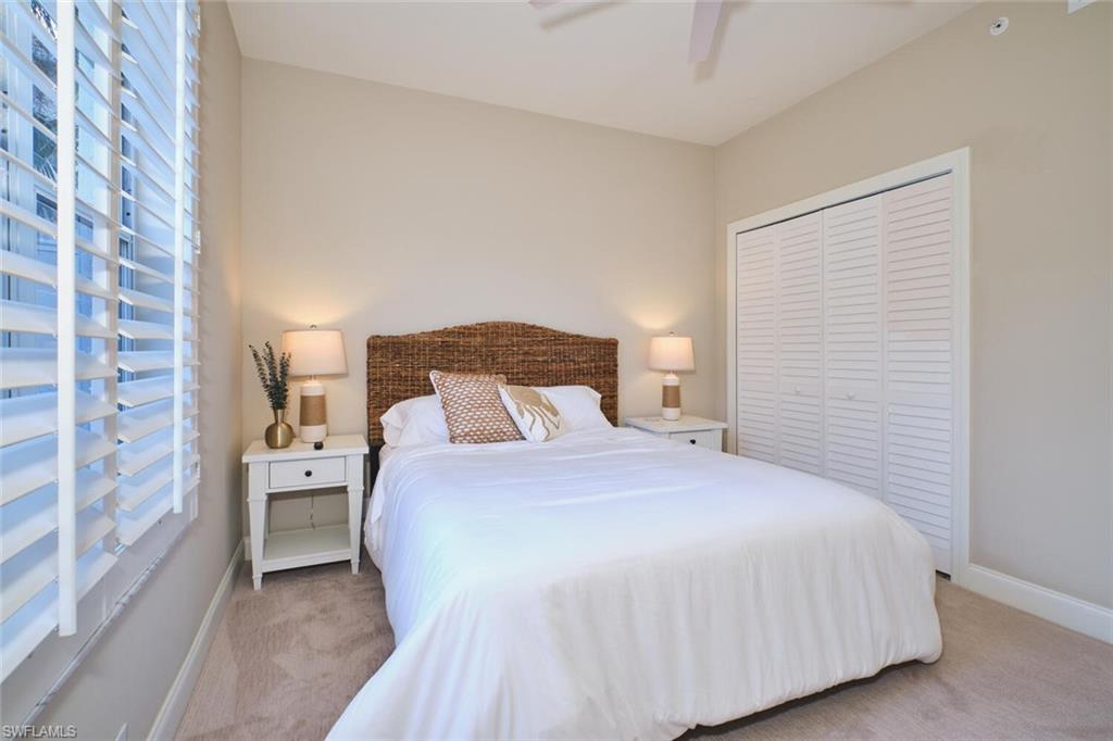 Bedroom featuring a closet, ceiling fan, and light carpet