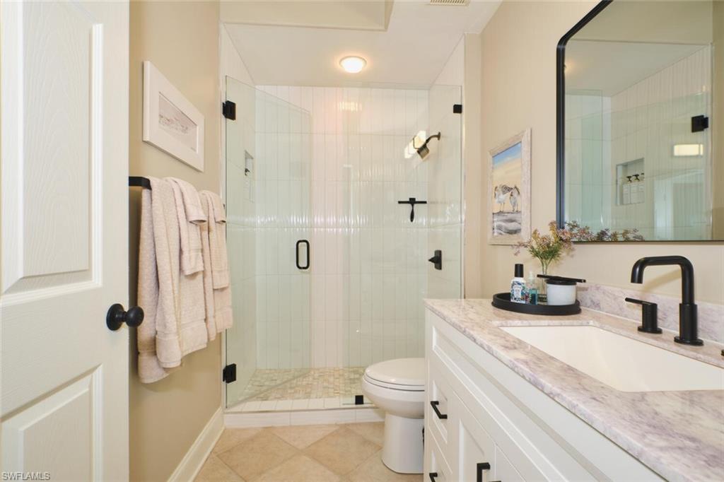 Bathroom featuring vanity, a stall shower, and light tile patterned floors