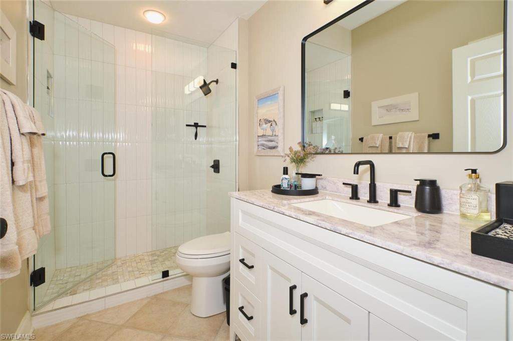 Full bath featuring vanity, a stall shower, and light tile patterned flooring