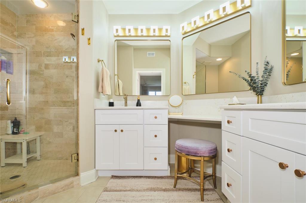 Full bathroom featuring vanity, a stall shower, and light tile patterned flooring