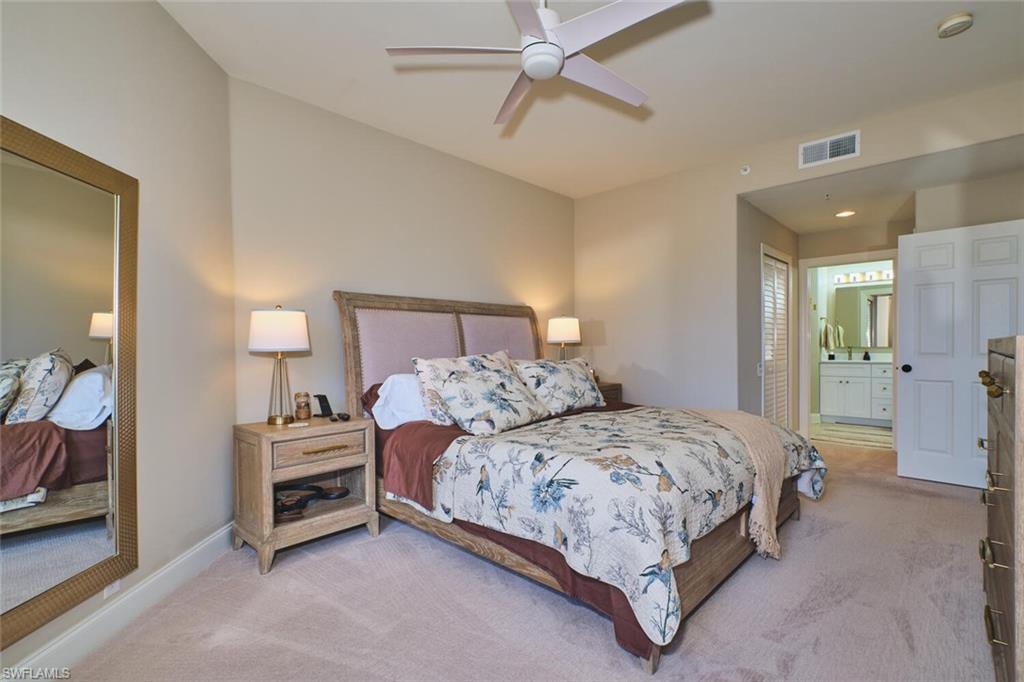 Bedroom with carpet, ensuite bathroom, and ceiling fan