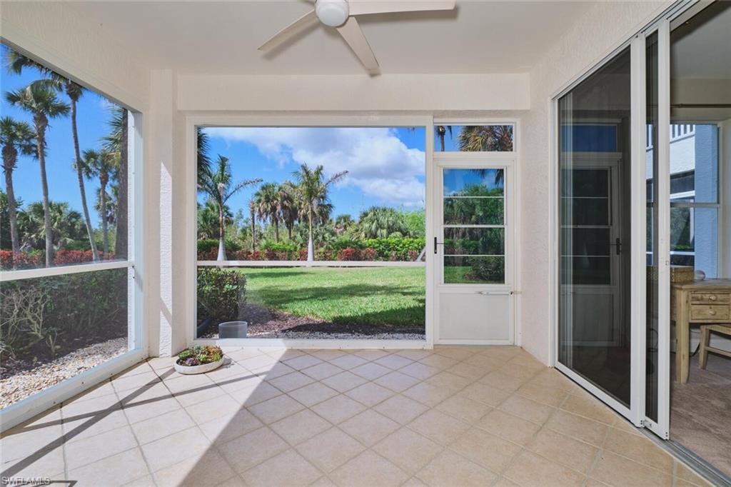 Unfurnished sunroom featuring ceiling fan and a patio area