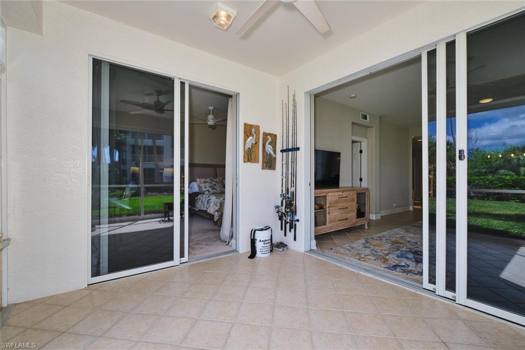 Unfurnished sunroom with a ceiling fan and a patio