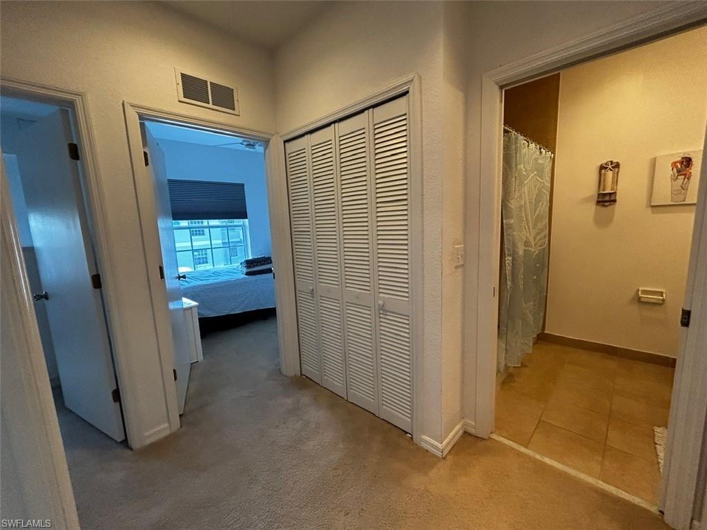 Hallway featuring light carpet and baseboards