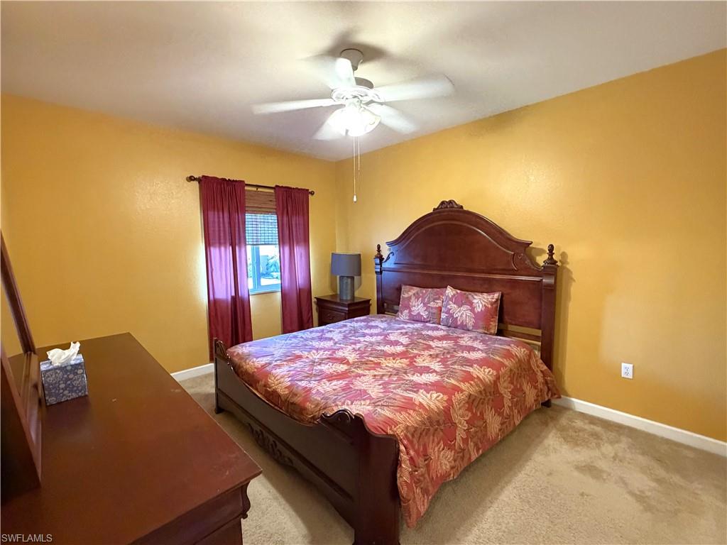 Large bedroom with carpet and ceiling fan with light