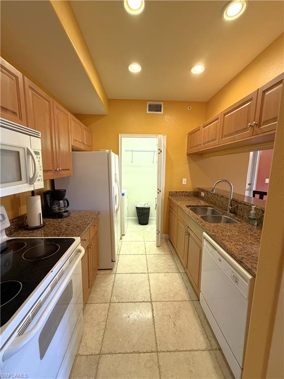 Recessed lighting, tile floors, and light wood cabinets