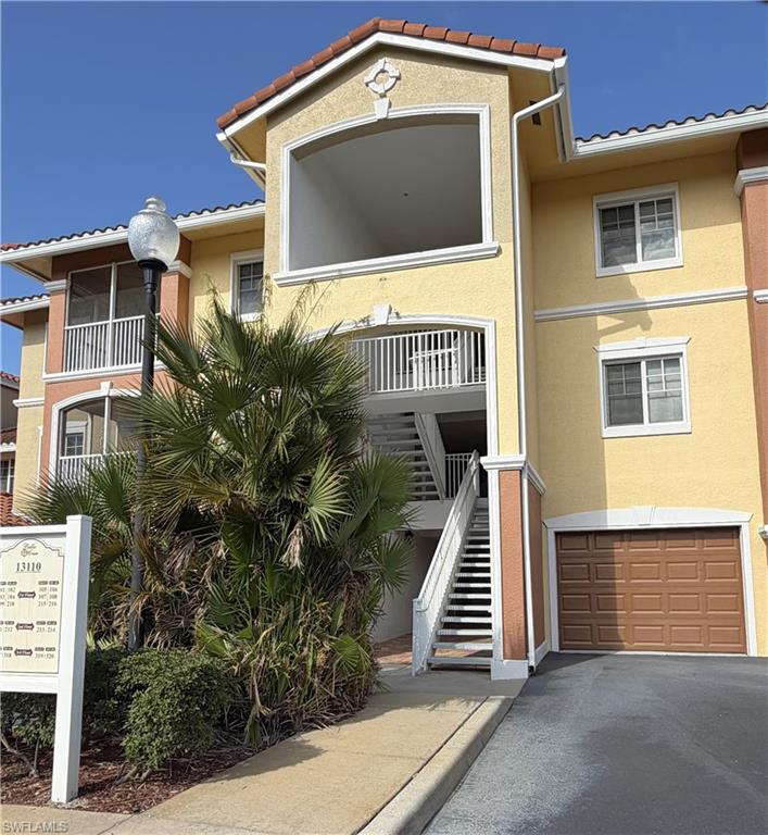 View of building exterior with an attached garage and driveway
