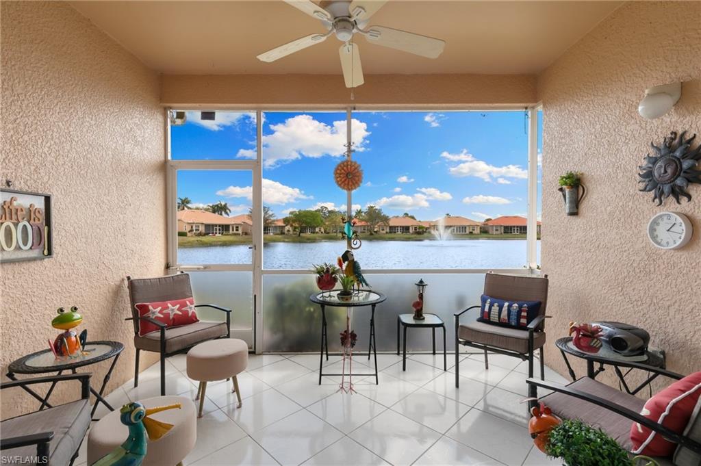 Sunroom featuring a textured wall, a residential view, and a water view
