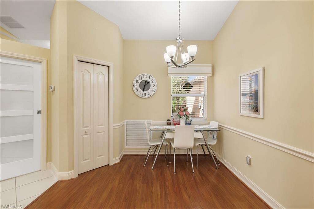 Dining room with dark wood-style flooring, a chandelier, and breakfast area