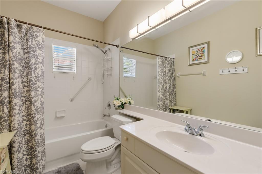 Bathroom featuring vanity, shower / tub combo with curtain, and plenty of natural light