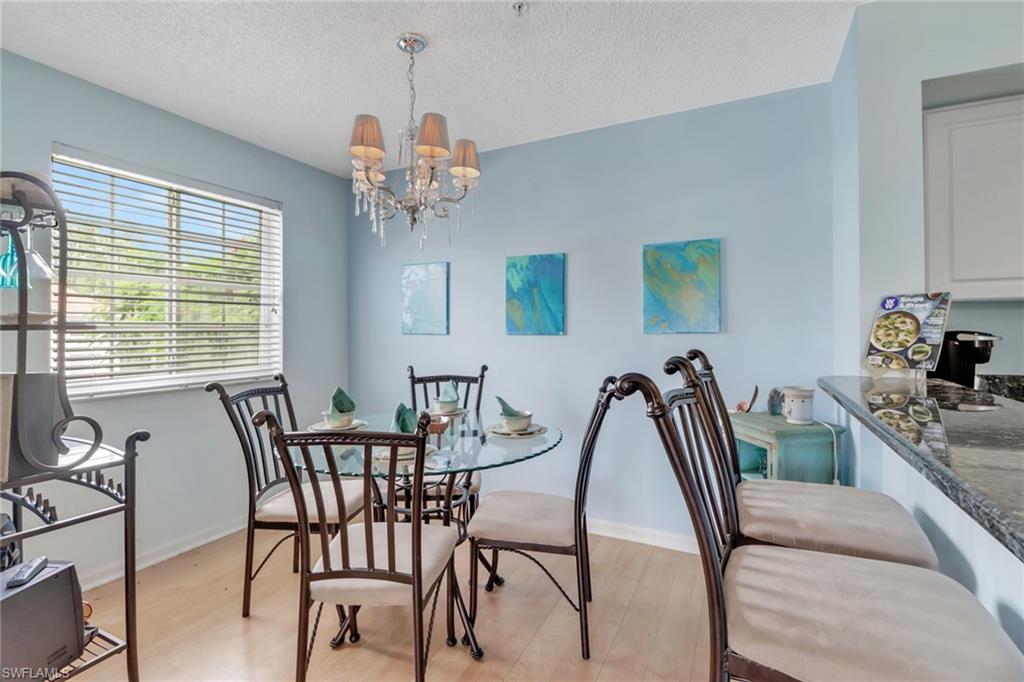 Dining space with a chandelier, light wood-type flooring, and a textured ceiling