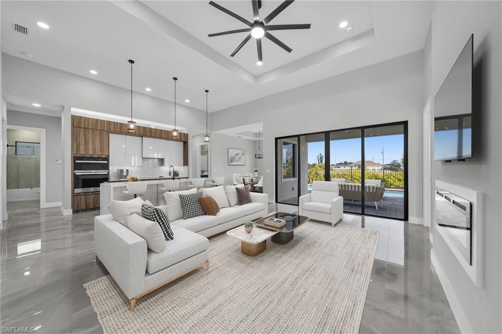 Living area featuring a ceiling fan, recessed lighting, and a high ceiling