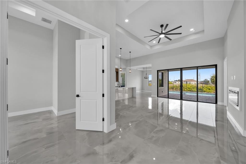 Spare room with ceiling fan, recessed lighting, and a tray ceiling