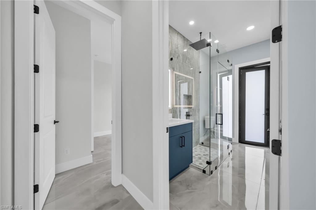 Bathroom featuring a marble finish shower, vanity, and recessed lighting