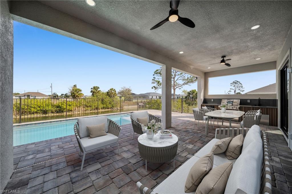 Fenced backyard with a ceiling fan, a patio, and outdoor lounge area
