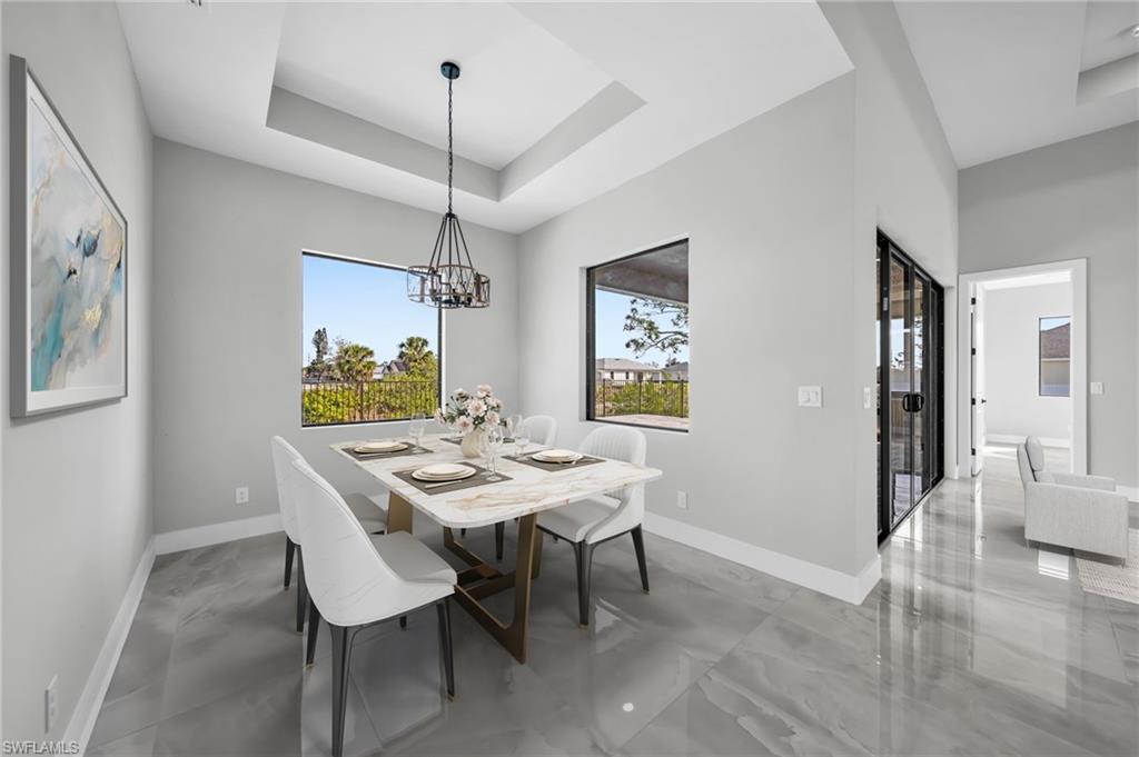 Dining room with a tray ceiling and a chandelier