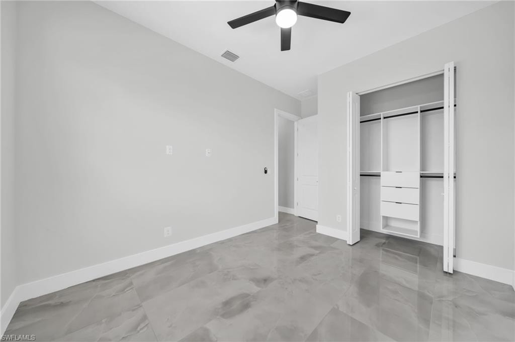 Unfurnished bedroom featuring a closet, ceiling fan, and finished concrete floors