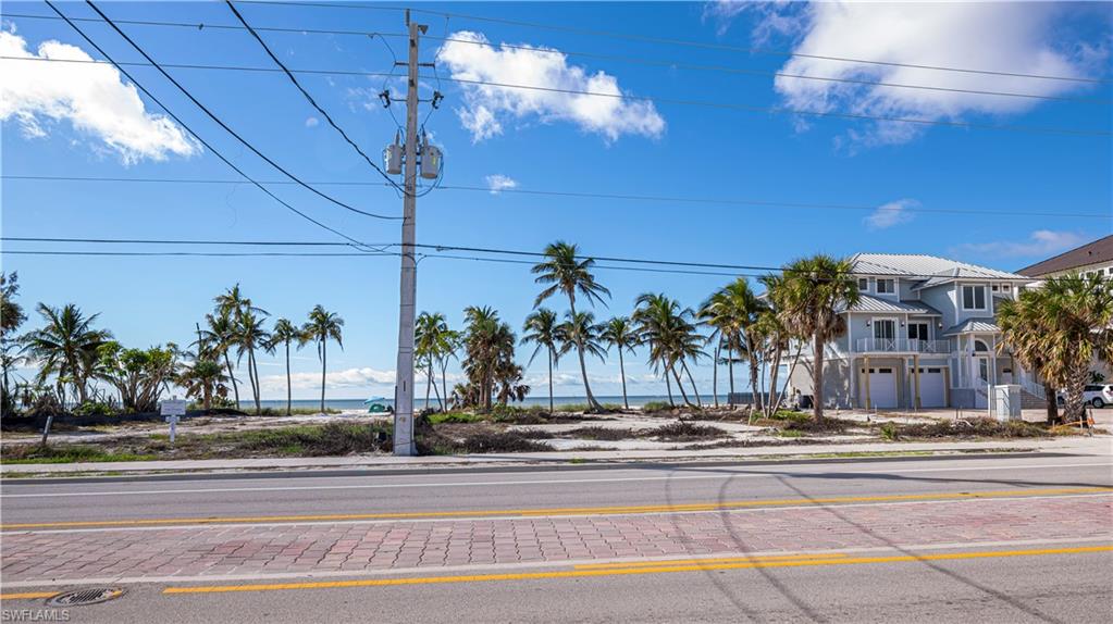 View of asphalt road with sidewalks, curbs, and a water view