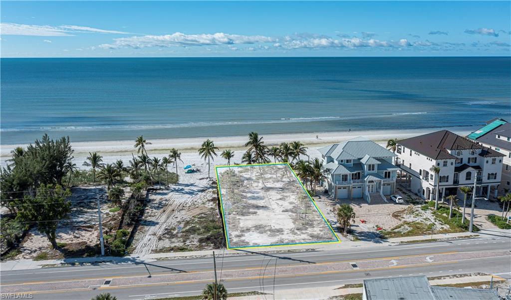 Aerial view of property and surrounding area with property boundaries highlighted and waterfront with a beach