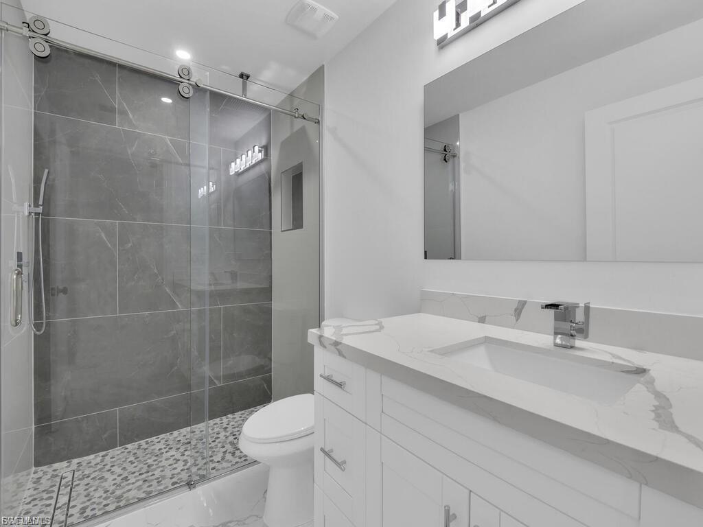 Bathroom featuring vanity and a shower stall