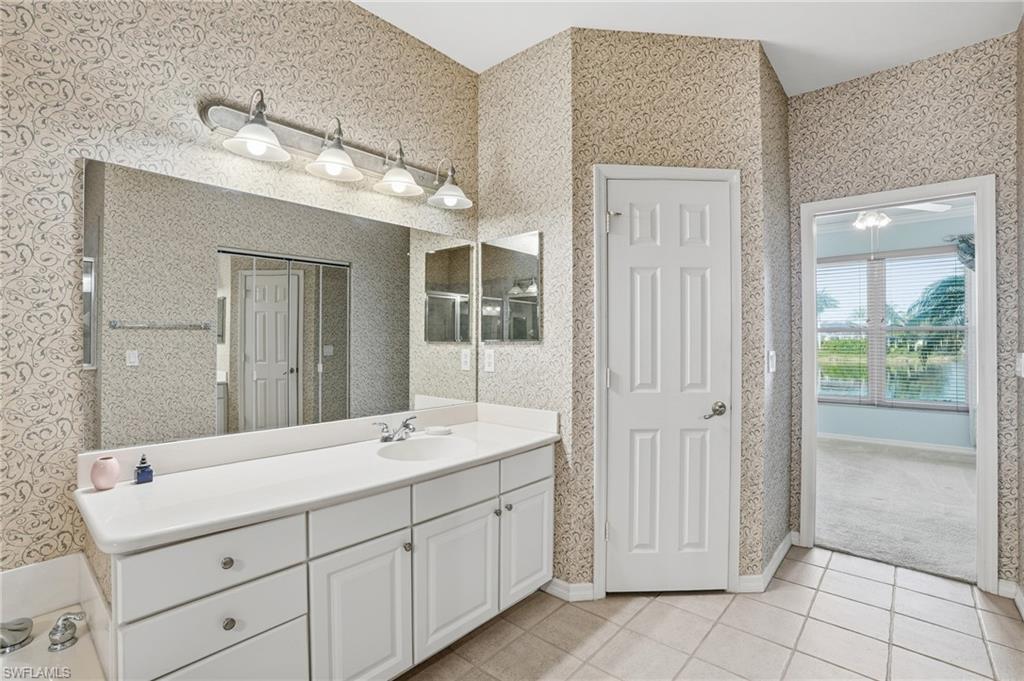 Bathroom featuring vanity and light tile patterned floors - Virtually Edited Image