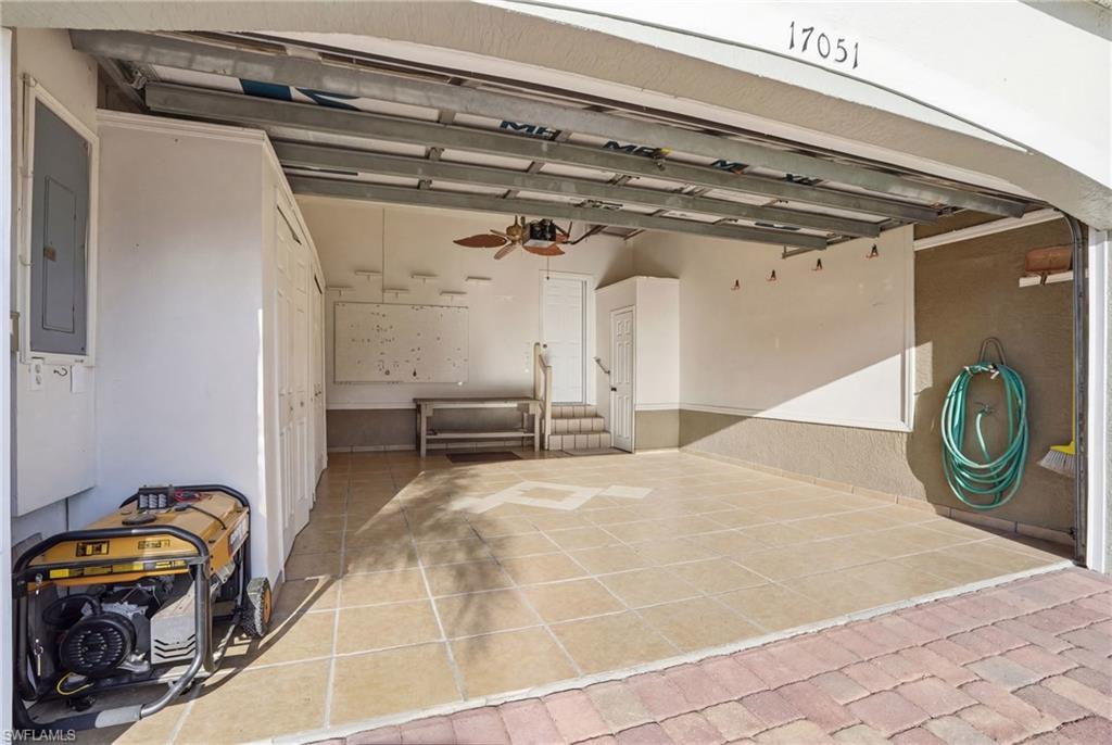 Garage featuring ceiling fan and electric panel - Virtually Edited Image