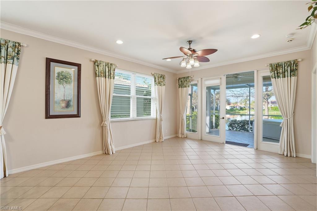 Empty room with a water view, a ceiling fan, light tile patterned floors, ornamental molding, and recessed lighting - Virtually Edited Image