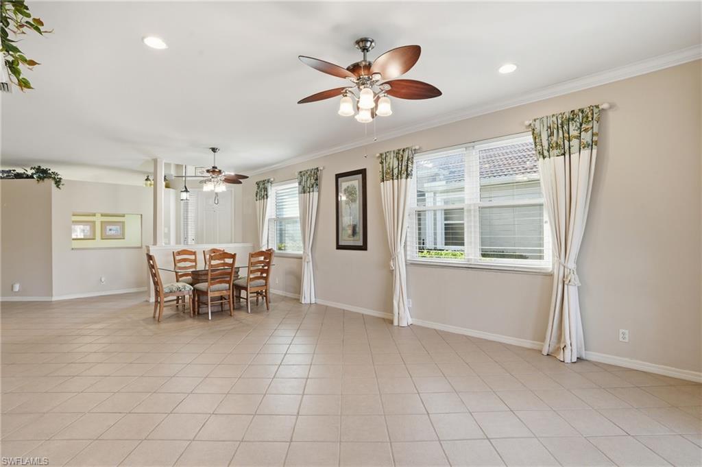 Dining space with ceiling fan, crown molding, light tile patterned flooring, and recessed lighting - Virtually Edited Image