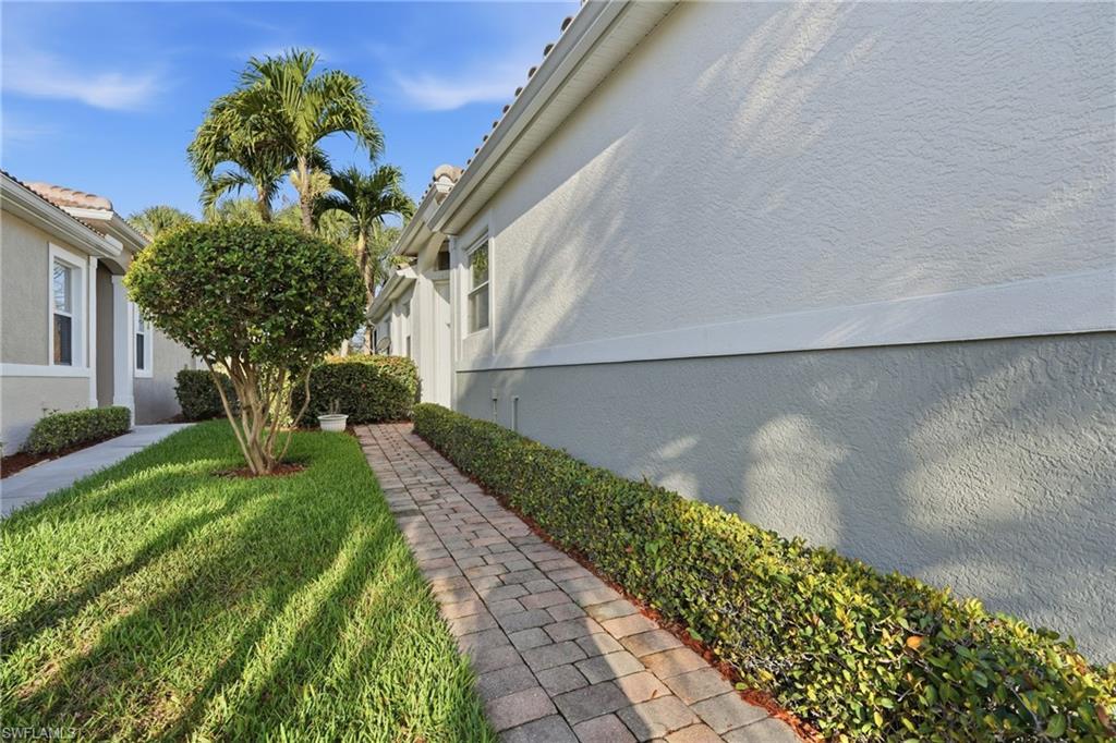 View of side of home featuring stucco siding and a yard - Virtually Edited Image
