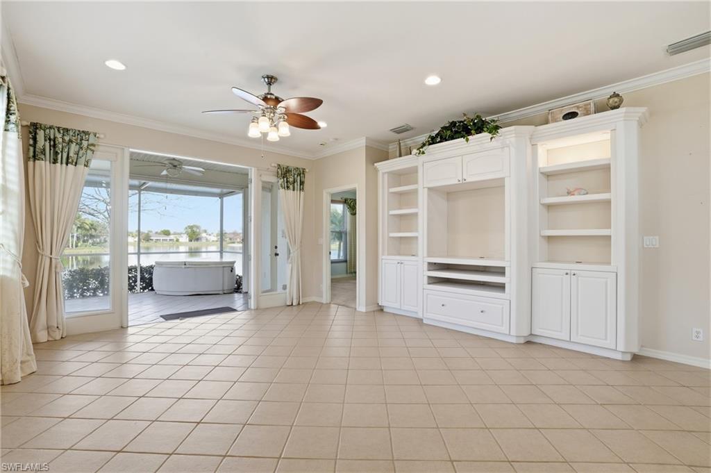 Unfurnished living room featuring ornamental molding, a ceiling fan, a water view, recessed lighting, and light tile patterned floors - Virtually Edited Image