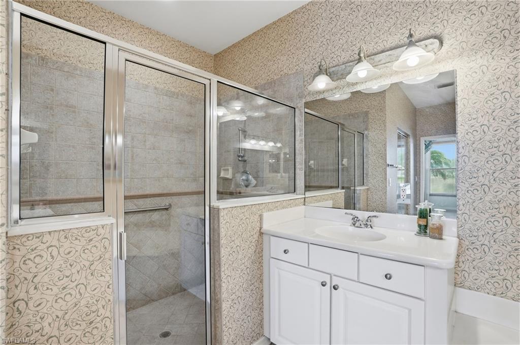 Full bathroom with wallpapered walls, vanity, and a shower stall - Virtually Edited Image