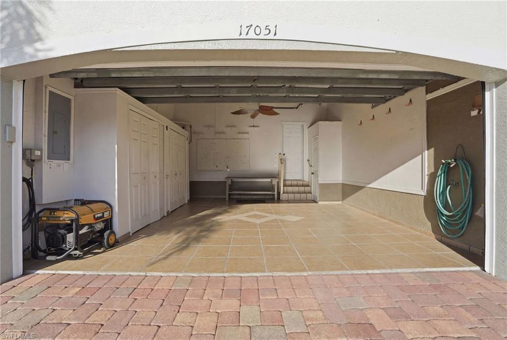 Garage featuring a ceiling fan and electric panel - Virtually Edited Image