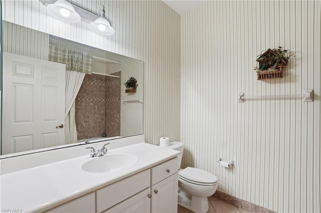 Bathroom featuring vanity and light tile patterned floors - Virtually Edited Image